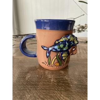 Blaue Keramik-Tasse mit flinkem Fisch